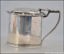 A silver hallmarked lidded mustard pot having a blue glass liner, assay marks for Sheffield,