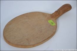 A Robert Mouseman Thompson oval bread board, with mouse carved to the handle.