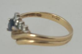 A 9ct gold, sapphire and diamond ladies ring. The teardrop sapphire surrounded by .