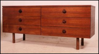 A 1970's retro teak wood sideboard raised on turned legs with a bank of six drawers having central