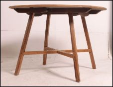 A 1970's retro beech and elm wood Ercol drop leaf dining table raised on squared angle legs with