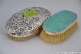 A silver hallmarked ladies clothes brush together with a Sterling silver marked rococo clothes