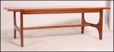 A retro 20th century teak and glass top coffee table raised on angled legs with rectangular inset