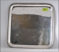 A sterling silver salver marked 925 of square form with gadrooned edges. No to verso 6897.