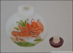 A Chinese oriental reverse glass painted snuff bottle depicting carp's in reed beds.