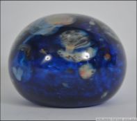 A 20th century studio ware glass paperweight having a swirl design and signed to the base.