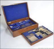 A Walker & Hall oak cased canteen of cutlery to include knives, forks, carving sets, ladel, tongs,