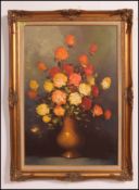 A 20th century large still life oil painting of flowers in vase set on canvas in a gilt molded