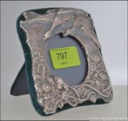 A silver hallmarked Art Nouveau picture frame cast in relief with swans, whirlpool and reeds etc.