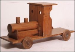 A 20th century vintage scratchbuilt large wooden sit on - pull along train with wheels.