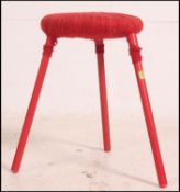 An unusual retro stool raised on a trio of tubular painted metal supports having a woolen weave