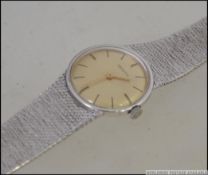 A Zenith silver ladies dress watch with bark effect silver strap bracelet.