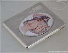 A silver card / cigarette case with nude female image to the front Measures: 10cms long.