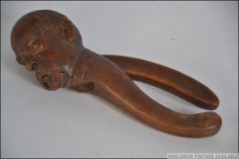A vintage treen nutcracker of good size in the form of a gentleman with moustache. 22cms long.