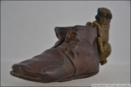 An Austrian cold painted bronze figure in the form of a pug aside an old shoe.