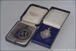 A silver hallmarked darts medal dating to 1913 together with an NRA Rifle club medal dating to 1860
