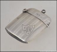 A silver hallmarked vesta case with armorial shield cartouche and monogram believed to be by Robert