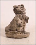 A reconstituted weathered garden ornament in the form of a playful dragon