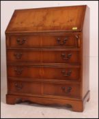 A Georgian style mahogany reproduction bureau having appointed interior with drawers beneath raised