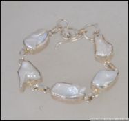 A contemporary silver and baroque pearl bracelet with bar and hoop mount. Marked 925.
