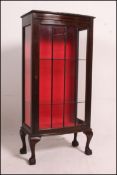 A 1930's Queen Anne revival mahogany display cabinet having full length glazed door raised on