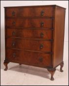 A mid 20th century straight five oak chest of drawers each with matching drop handles raised on