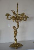 A 19th century brass rococo 4 branch candelabra hacing cherub / putti column over cloven foot base,