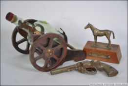 A retro 1970's brandy bottle cannon holder together with a silver plated trophy of a horse and a