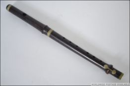 A rosewood one keyed flute being nickel mounted dating to the early 20th century