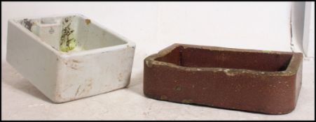 A vintage ceramic Belfast sink used as a garden planter along with another sink / garden planter.