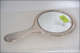 A silver hallmarked hammered dressing table mirror bearing Chester hallmarks for J & R Griffin