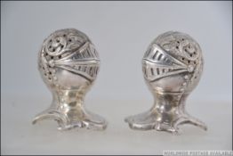A Victorian style silver plated pair of novelty pepper pots in the form of a knights helmet marks