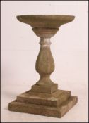 A weathered composition Bath stone 3-sectional bird bath of circular form raised on a baluster