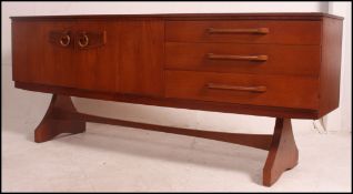 A 1970's teak wood sideboard comprising a series of drawers and cupboards being raised on angled