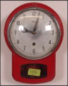A retro / vintage Smiths cast metal case kitchen wall clock having a deep red finish with pendulum