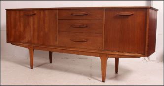 A 1970's teak sideboard in the Danish style being raised on tapered legs with a series of cupboards