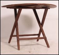 An early 20th century campaign / coaching table having folding design with circular table top