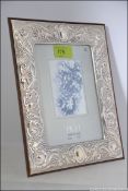 A silver hallmarked picture frame in the rococo style with glass panel centre and easel back.