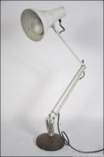 A retro 20th century Herbert Terry Anglepoise Lighting Ltd desk lamp in white raised on a circular