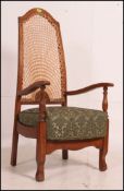 A 1930's Art Deco walnut bergere armchair having overstuffed seat with caned back rest