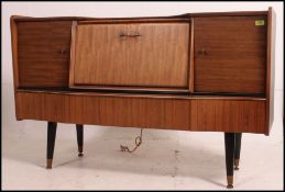 A retro 20th century sideboard cocktail cabinet by Beautility having a central fall front door