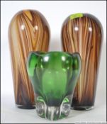A pair of studio glass vases on brown ground along with a heavy studio dump glass iridescent dish.