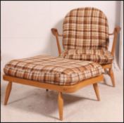 A Ercol Windsor pattern 1970's armchair and ottoman footstool in beech and elm.