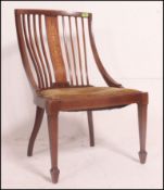 An Edwardian mahogany salon armchair having square tapered legs with spade feet,