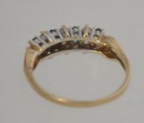 A hallmarked 9ct gold ring set with green and clear ge stones. Hallmarked for London. Weight 1.8g.