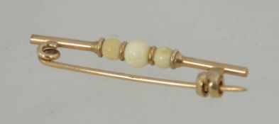 A early 20th century 9ct gold bar brooch with ivory ball styling with clip c clasp. Measures 3.3cms.