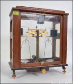 A set of early 20th century mahogany cased Industrial scientific Oertling brass beam balance scales.