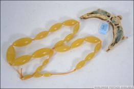 A celluloid handbag top / clasp carved in the form of storks facing a flower head together with a