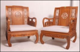 A pair of Chinese low elbow / arm chairs, each with open carved backs,