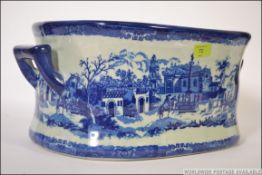 A 19th century style blue and white foot bath, of oval form decorated with Italianate landscapes.